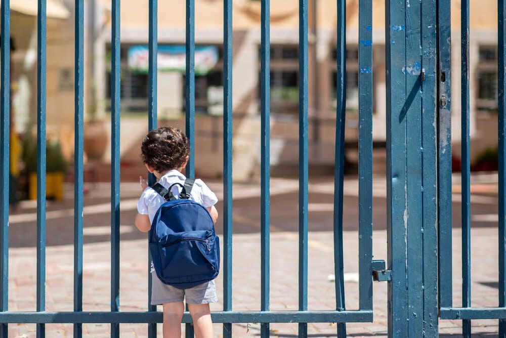 Kid,with,school,backpack,look,on,schoolyard,towards,an,open