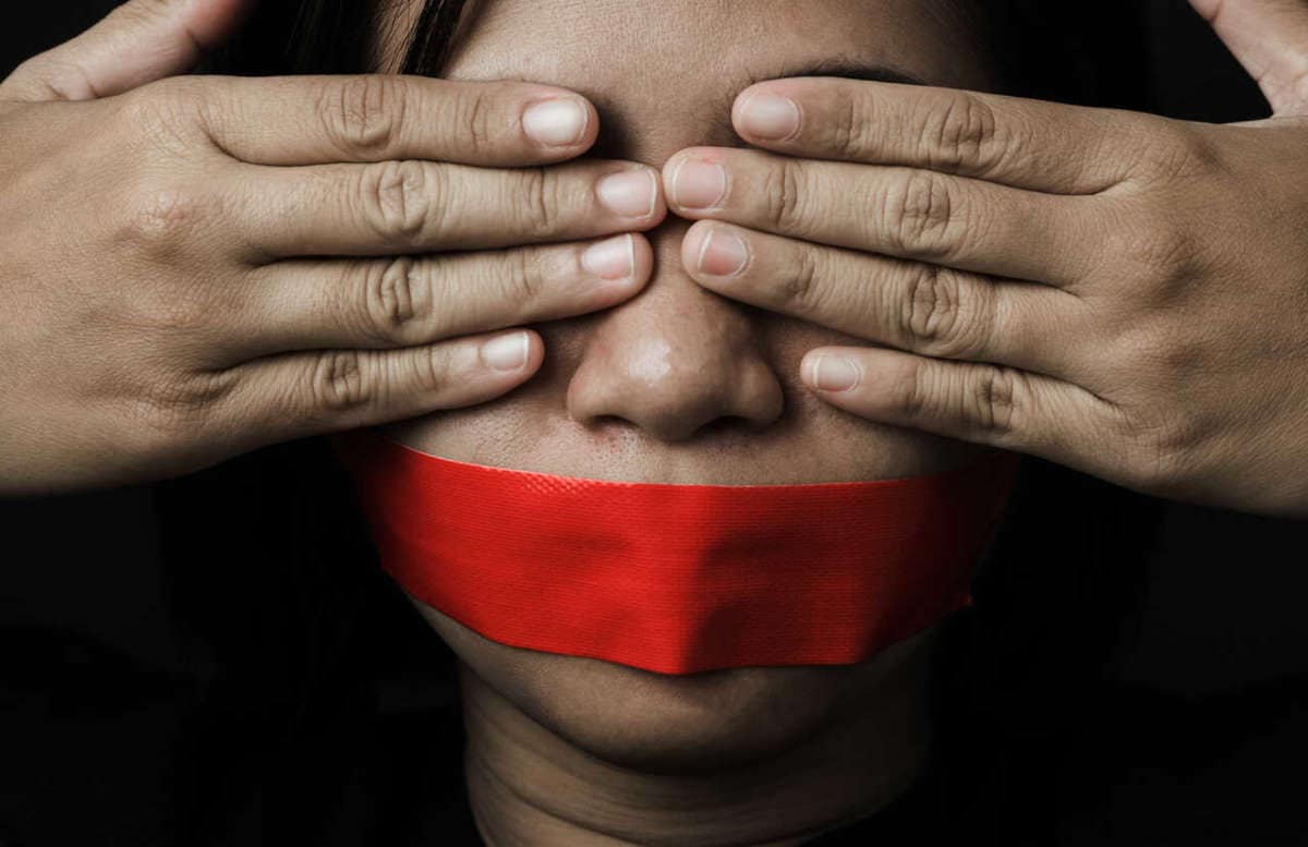 Asian,woman,blindfold,wrapping,mouth,with,red,adhesive,tape,on